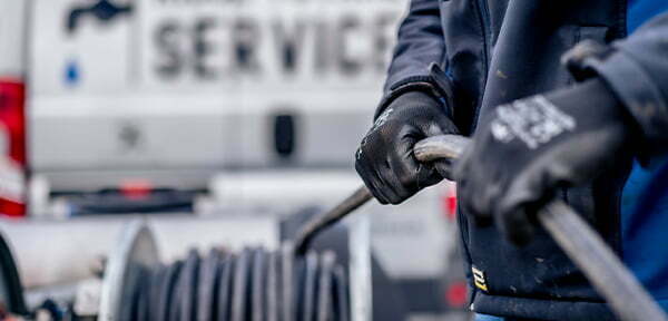 Monteur haalt gereedschap uit de bedrijfsbus van Riool Totaal Service